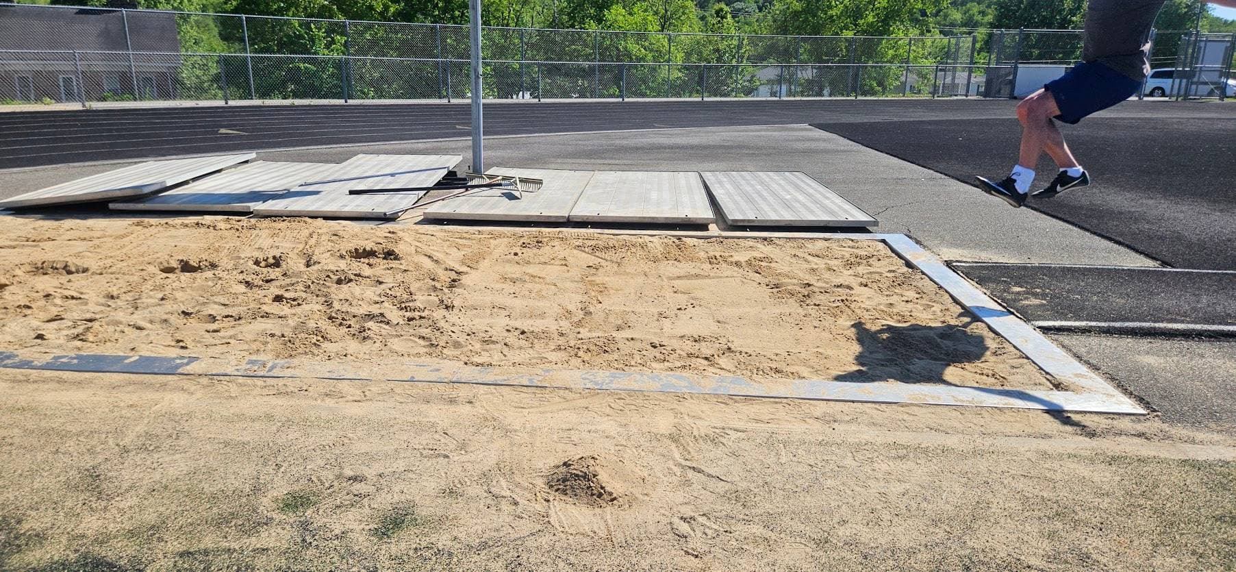 A long jump pit, with Tobe's feet just making it into the top corner of the picture.